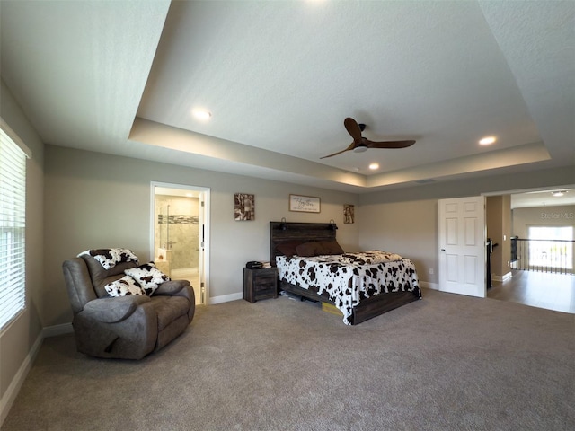 bedroom with a tray ceiling, carpet, recessed lighting, ceiling fan, and baseboards