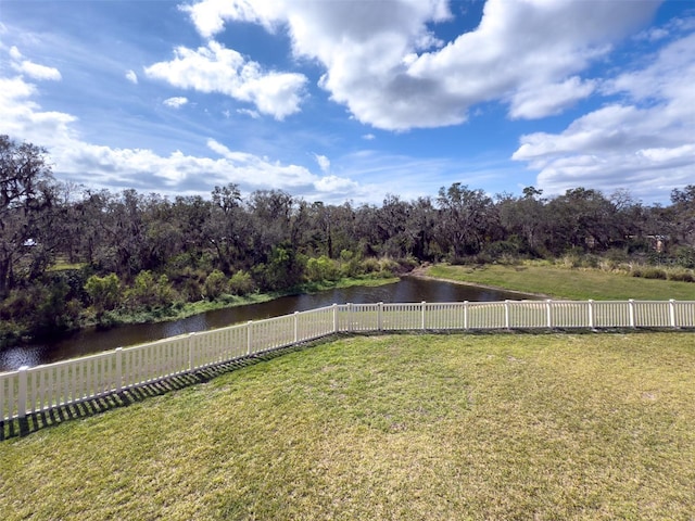view of yard with a water view and fence