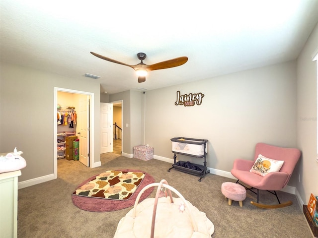 recreation room with carpet floors, a ceiling fan, visible vents, and baseboards