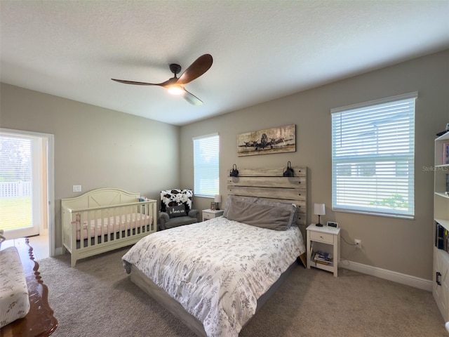 bedroom featuring carpet, a textured ceiling, baseboards, and a ceiling fan