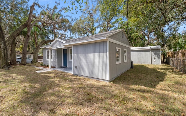 back of house with fence and a lawn