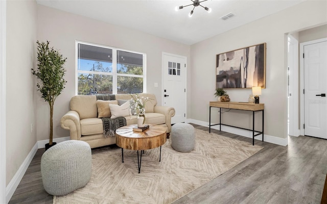 sitting room with baseboards, visible vents, and wood finished floors