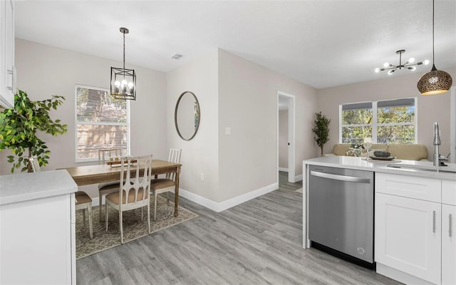 kitchen with white cabinetry, an inviting chandelier, and stainless steel dishwasher