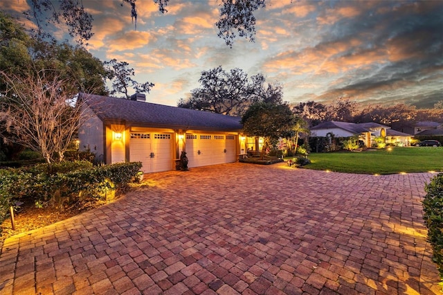 view of front facade featuring a garage, a front yard, decorative driveway, and a chimney