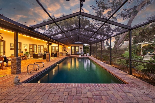 outdoor pool with glass enclosure, french doors, outdoor lounge area, and a patio