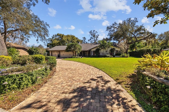 view of front of home with a garage, decorative driveway, and a front lawn