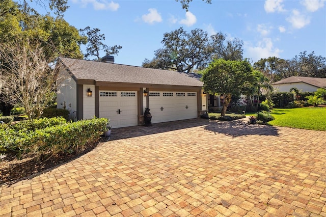 view of front of property with a front yard, decorative driveway, and a chimney