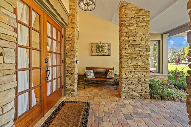 hallway with brick floor and lofted ceiling