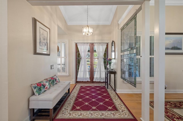 entrance foyer with ornamental molding, french doors, baseboards, and wood finished floors