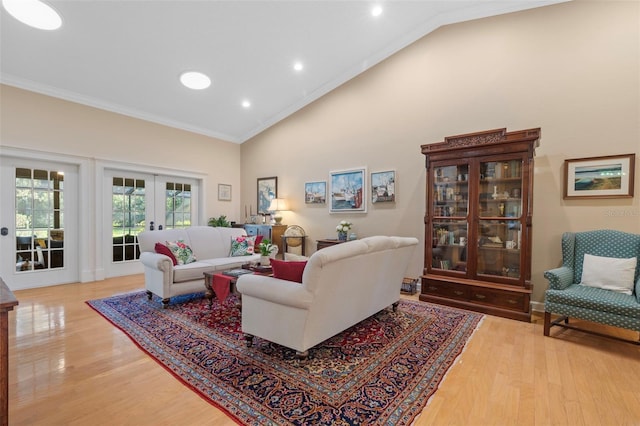 living area featuring crown molding, high vaulted ceiling, french doors, and light wood-style floors