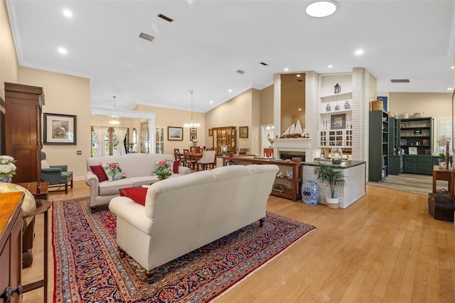 living area with crown molding, a fireplace, lofted ceiling, visible vents, and light wood-type flooring