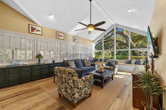 living room featuring a textured ceiling, light wood-type flooring, a wealth of natural light, and a ceiling fan