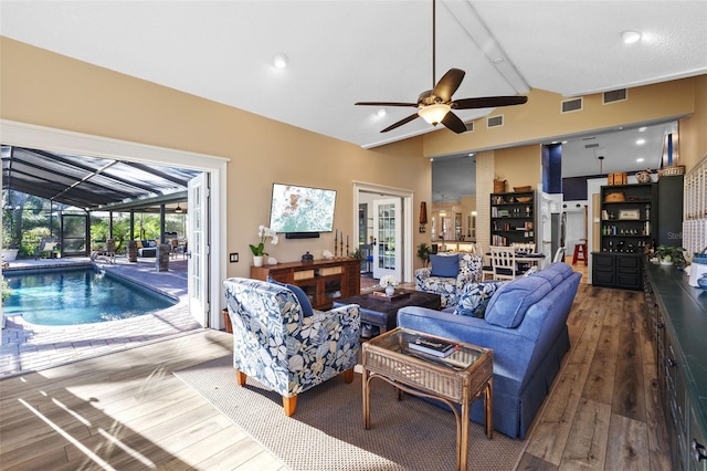 living room featuring vaulted ceiling, hardwood / wood-style flooring, and visible vents