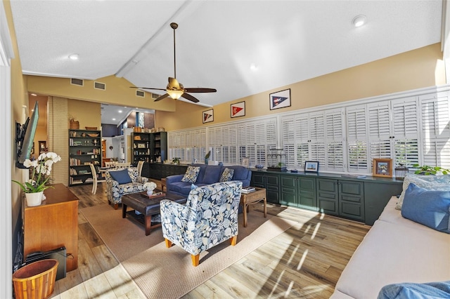 living area featuring visible vents, wood finished floors, beam ceiling, and a ceiling fan