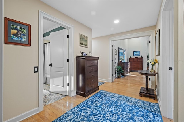 hallway featuring light wood-style floors, recessed lighting, and baseboards