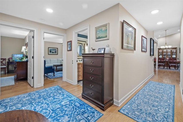 hall with a notable chandelier, recessed lighting, baseboards, and light wood-style floors