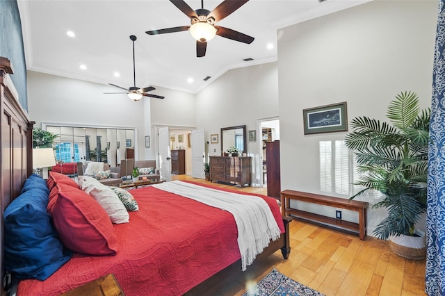 bedroom featuring high vaulted ceiling, a ceiling fan, visible vents, light wood-style floors, and crown molding