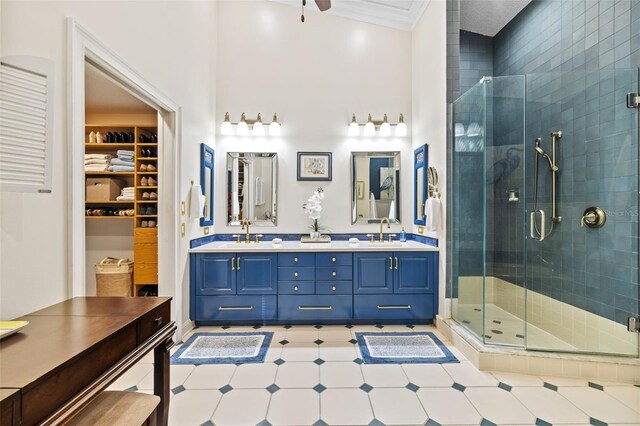 bathroom with a shower stall, ornamental molding, and a sink