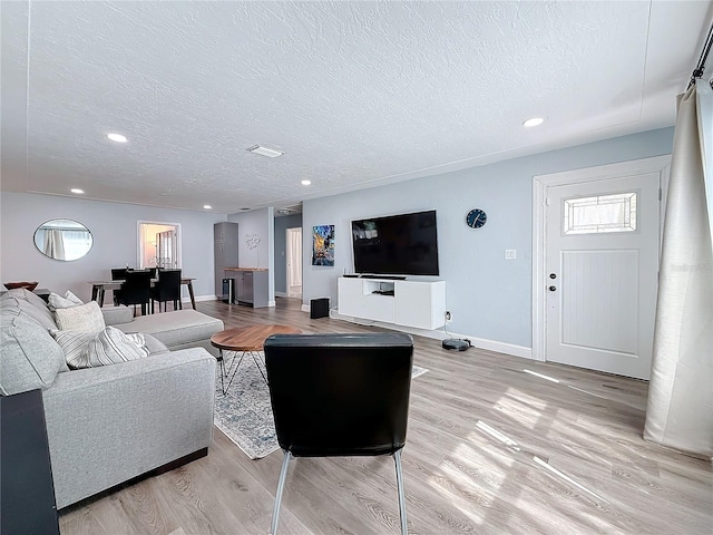 living room with light hardwood / wood-style floors and a textured ceiling