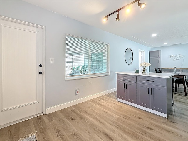 kitchen featuring a center island, light hardwood / wood-style flooring, gray cabinetry, and track lighting