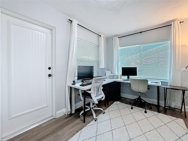 office with light hardwood / wood-style floors and a textured ceiling