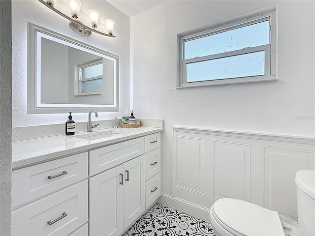 bathroom with toilet, vanity, and tile patterned flooring