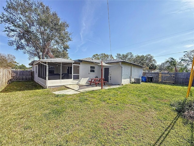 rear view of house featuring a patio area, a yard, a sunroom, and cooling unit