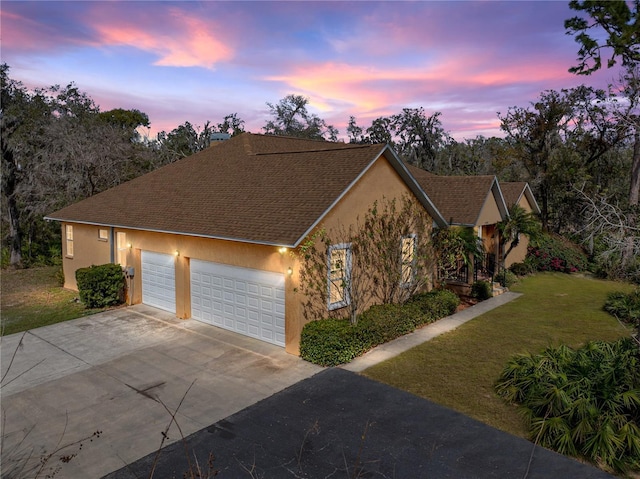 view of front of house featuring a garage and a yard