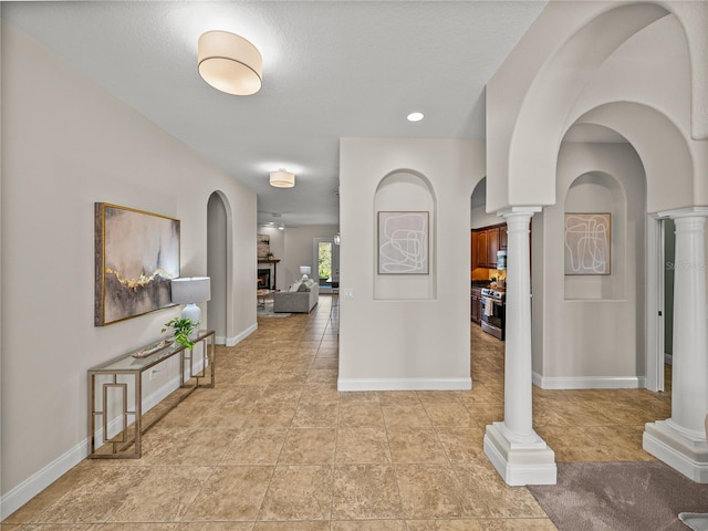 corridor featuring ornate columns and a textured ceiling