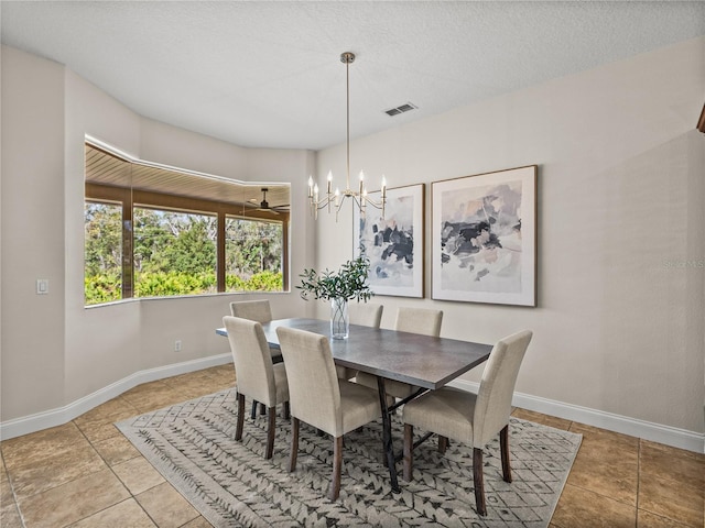 tiled dining room with a textured ceiling and a notable chandelier