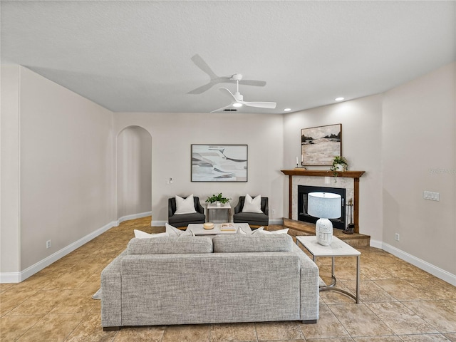 living room with ceiling fan and a textured ceiling