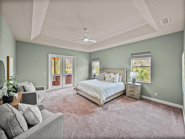 carpeted bedroom featuring a textured ceiling, ceiling fan, a raised ceiling, french doors, and access to outside