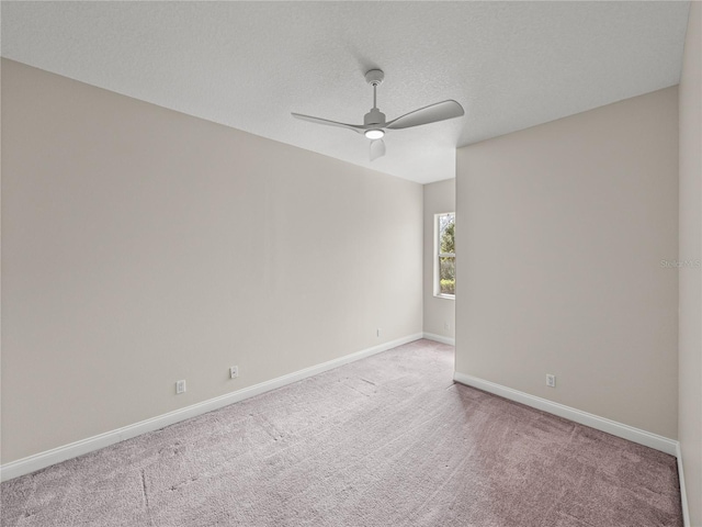 spare room with a textured ceiling, ceiling fan, and light colored carpet