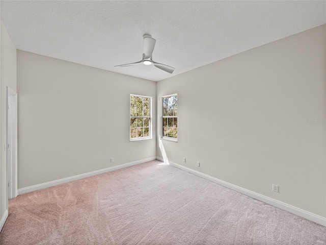 spare room with a textured ceiling, ceiling fan, and light colored carpet