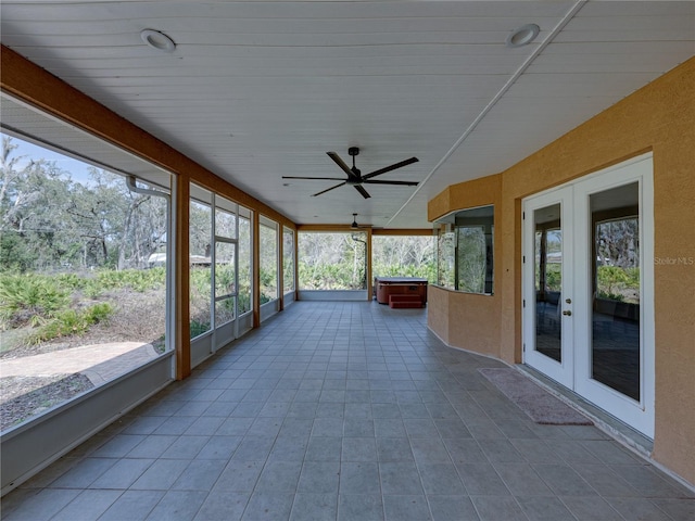 unfurnished sunroom with ceiling fan and french doors