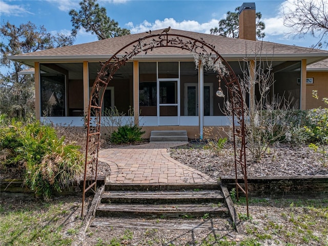 back of property with a sunroom