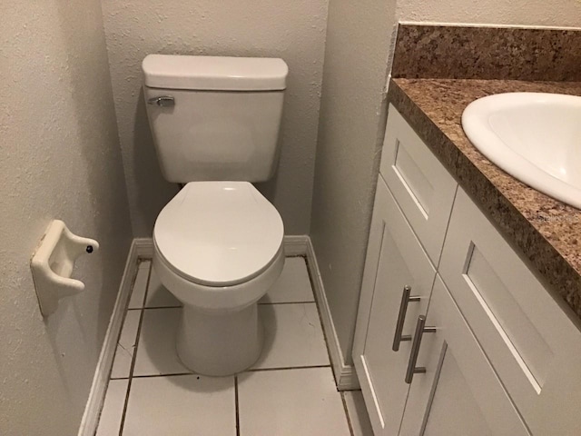 bathroom featuring a textured wall, vanity, and toilet