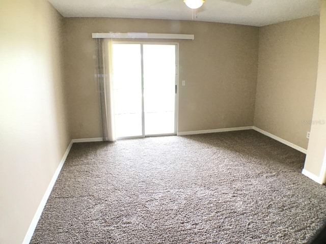 spare room with carpet flooring, a ceiling fan, and baseboards