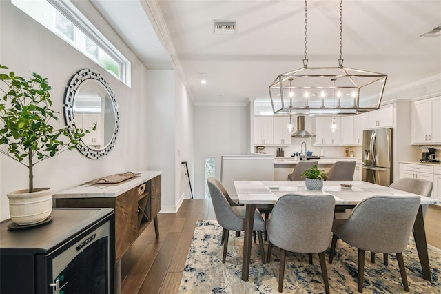 dining area with sink, ornamental molding, and dark hardwood / wood-style floors