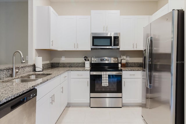 kitchen featuring white cabinets, appliances with stainless steel finishes, sink, and light stone counters