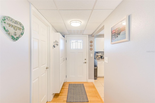 doorway featuring a paneled ceiling and light wood finished floors