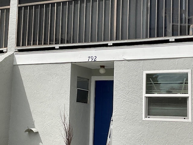 doorway to property featuring stucco siding