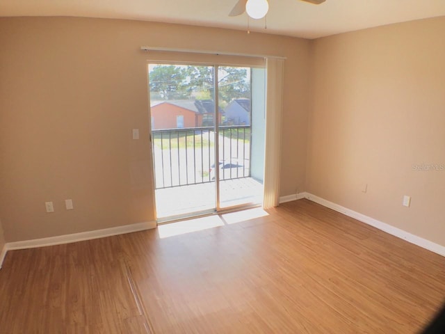 empty room featuring ceiling fan, baseboards, and wood finished floors