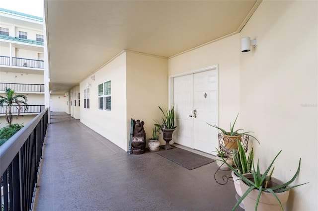 view of exterior entry with a balcony and stucco siding