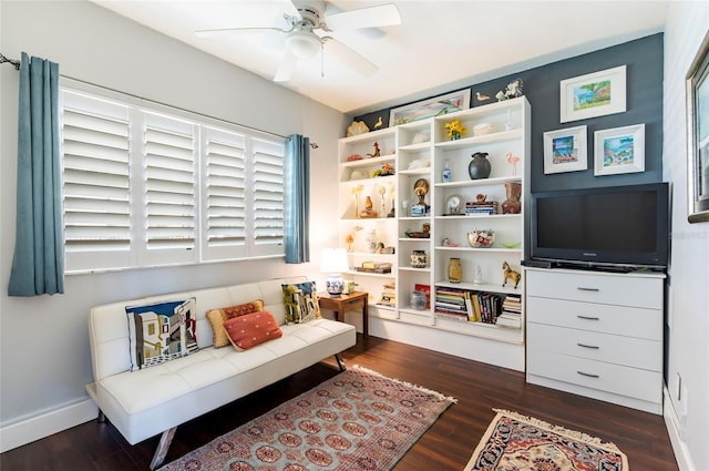 living area with dark wood-type flooring, ceiling fan, and baseboards