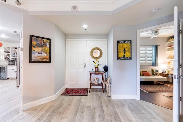 entrance foyer with light wood-style floors, wine cooler, ceiling fan, and baseboards