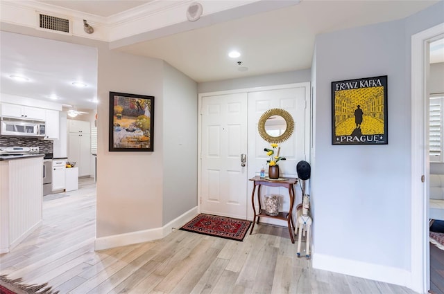 foyer entrance featuring light wood-type flooring, visible vents, and baseboards