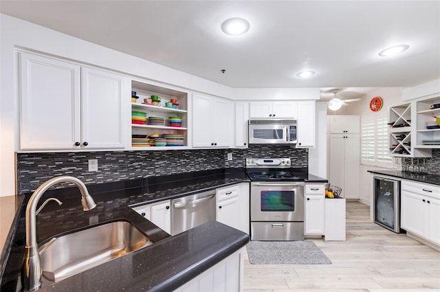 kitchen with wine cooler, stainless steel appliances, a sink, white cabinets, and open shelves