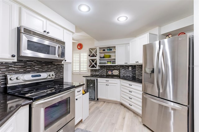 kitchen featuring light wood finished floors, white cabinets, wine cooler, stainless steel appliances, and open shelves