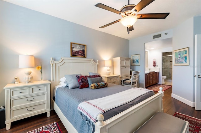 bedroom with ensuite bathroom, dark wood-type flooring, visible vents, and baseboards